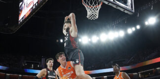 Jugadores de Valencia Basket y Girona en un emocionante partido de baloncesto.