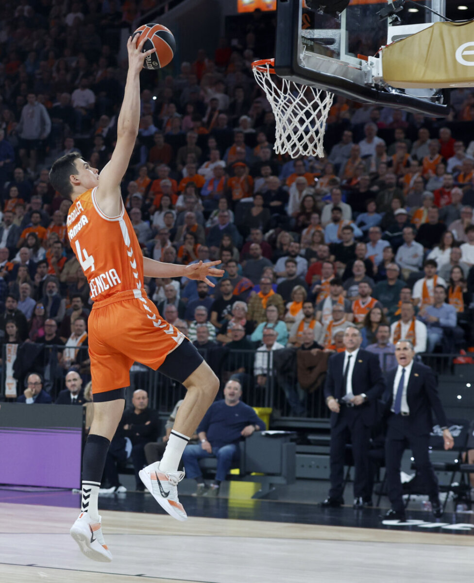 Jugador de Valencia Basket realizando un mate en el Roig Arena durante un partido.