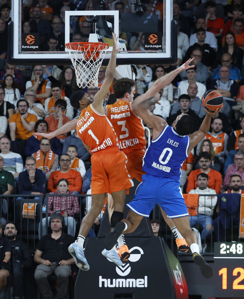 Jugadores de Valencia Basket defendiendo un tiro de Lyles del Real Madrid