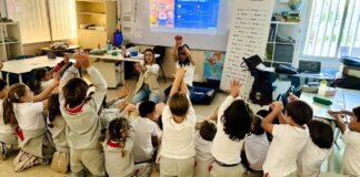 Niños aprendiendo reanimación cardiopulmonar en clase