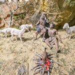 Escena de pastores con ovejas y fuego en el suelo.