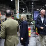 Personas en la inauguración de Expojove 2025 con vehículos militares