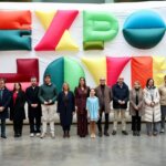 Grupo de personas en la inauguración de Expojove 2025 con un fondo colorido