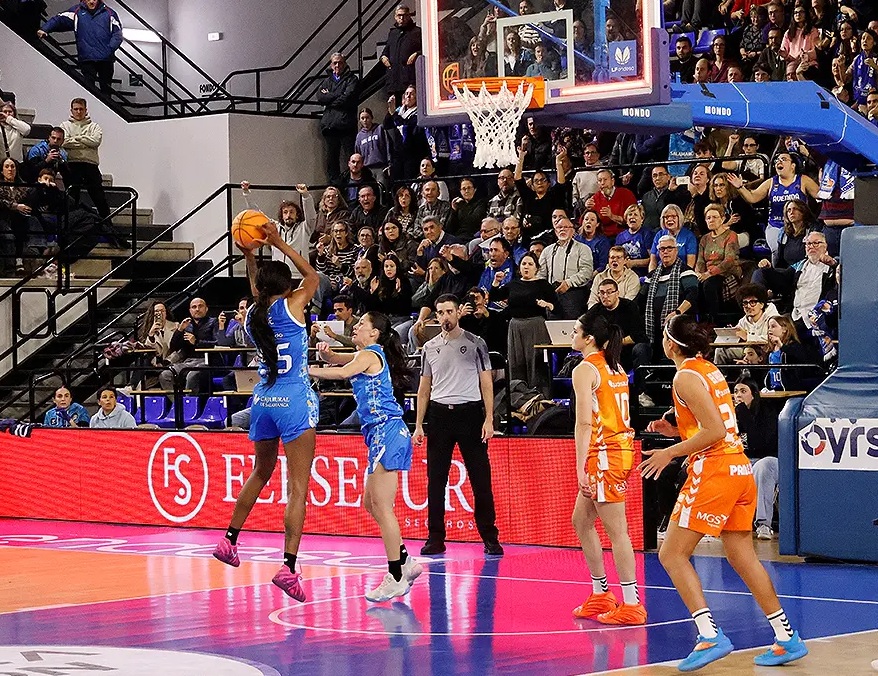Jugadora lanzando a canasta en un partido de baloncesto entre Valencia Basket y Perfumerías Avenida.
