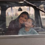 Mujer y niña sonriendo dentro de un vehículo en Expojove 2025