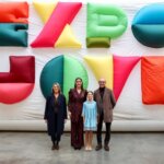 Cuatro personas posando frente a un fondo colorido de Expojove 2025