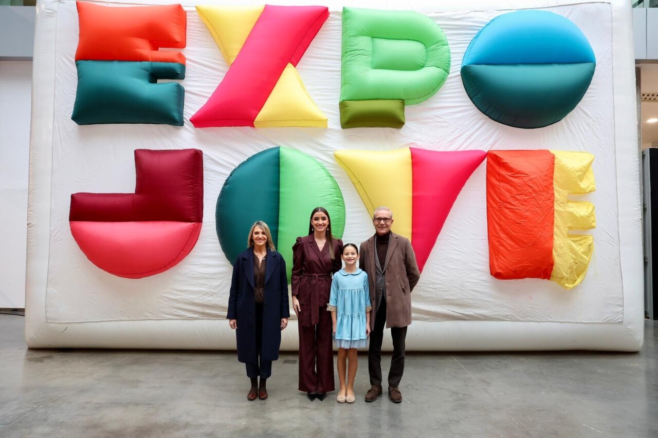 Cuatro personas posando frente a un fondo colorido de Expojove 2025