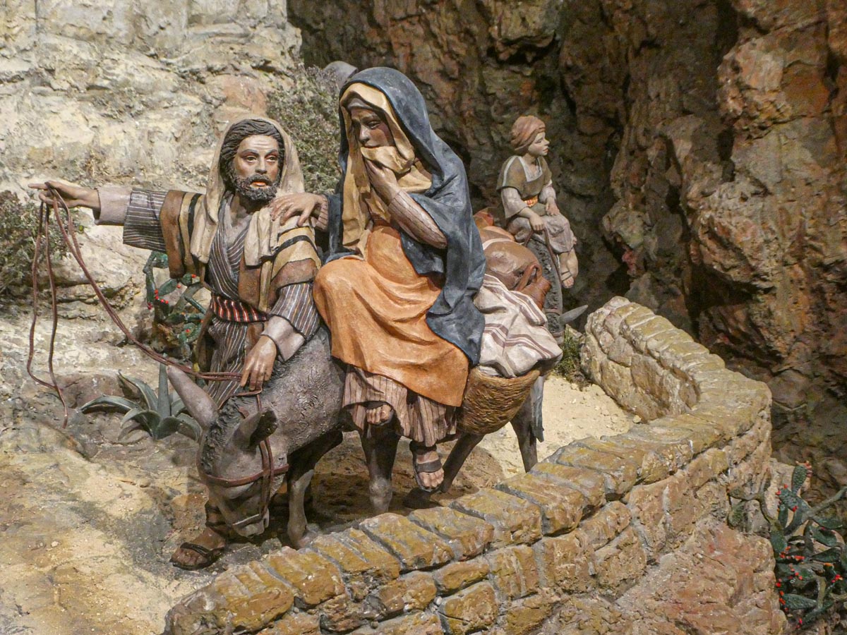 Figuras artesanales de la natividad con un burro y personajes bíblicos.