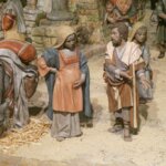 Figuras artesanales de la natividad con un burro en el fondo.
