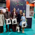 Grupo de personas en la inauguración de Expojove 2025 sosteniendo bolsas