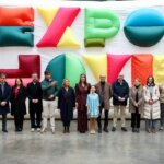 Grupo de personas en la inauguración de Expojove 2025 con fondo colorido