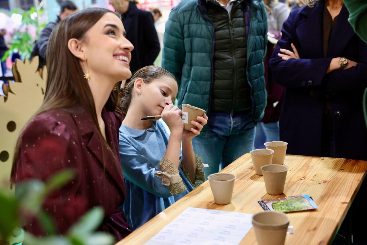 Mujer sonriente y niña dibujando en un evento de Expojove 2025