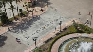 Vista aérea del cartell toponímic en Valencia con personas caminando
