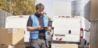 Repartidor con caja y furgonetas de fondo en Valencia