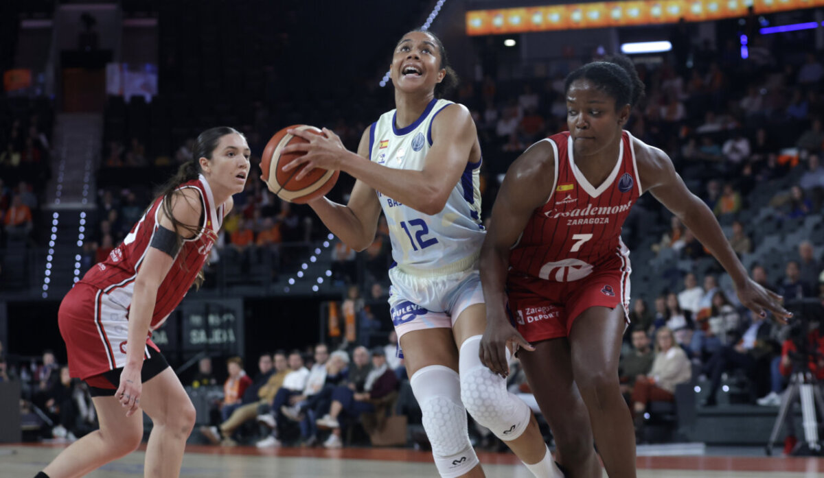 Jugadoras de Valencia Basket y Casademont Zaragoza compiten por el balón en un partido emocionante.
