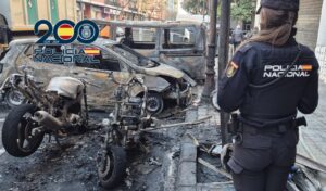 Policía Nacional observando vehículos quemados en Valencia tras un incendio