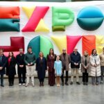 Grupo de personas en la inauguración de Expojove 2025 con un fondo colorido.