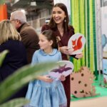 Personas sonrientes sosteniendo carteles de animales en Expojove 2025