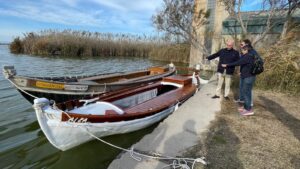 Barca eléctrica tradicional en el lago de Albufera con personas observando