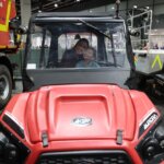 Mujer y niño sonriendo dentro de un vehículo en Expojove 2025