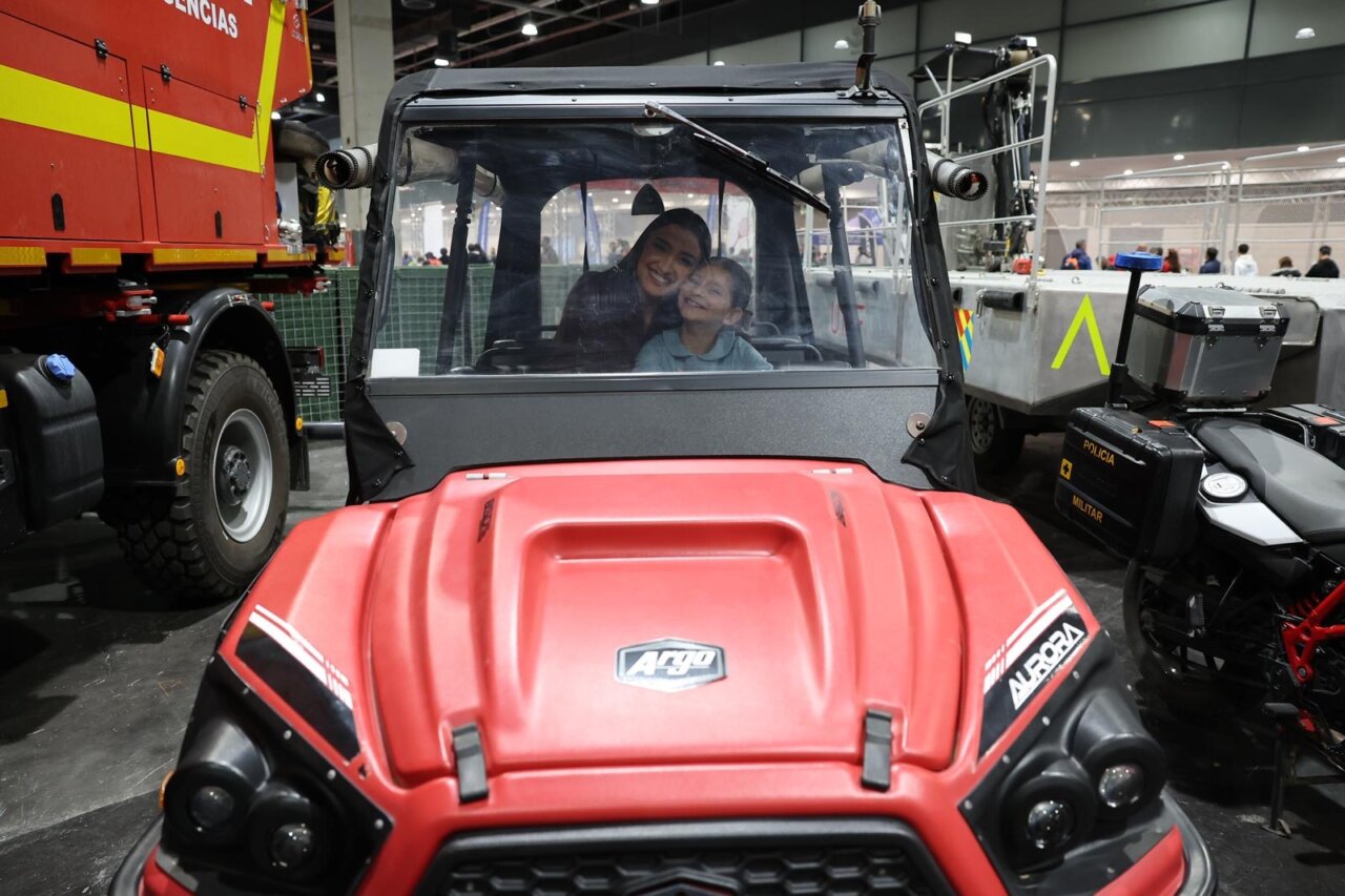 Mujer y niño sonriendo dentro de un vehículo en Expojove 2025