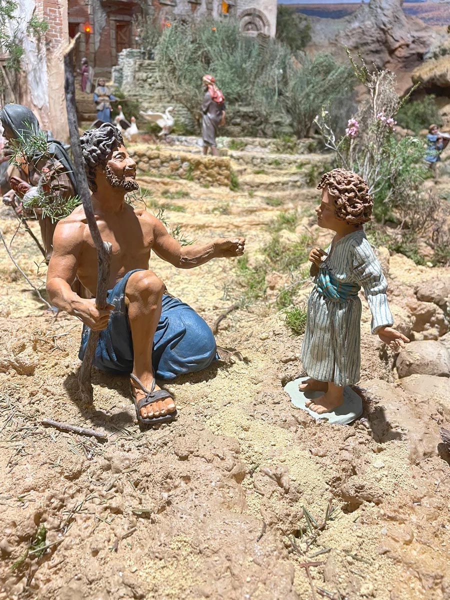Escena del Belén Monumental con figuras de un pastor y un niño.