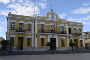 Fachada del Ayuntamiento de Burjassot con banderas y cielo azul