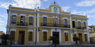 Fachada del Ayuntamiento de Burjassot con banderas y cielo azul