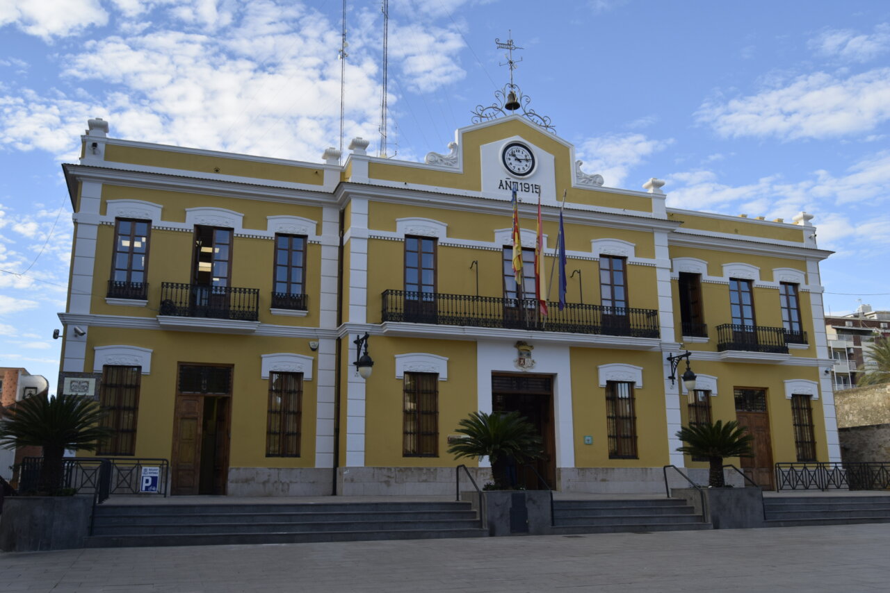 Fachada del Ayuntamiento de Burjassot con banderas y cielo azul