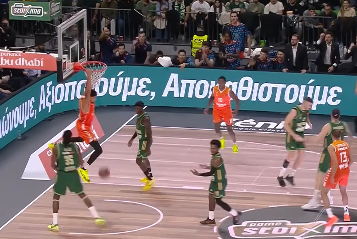 Jugador de Valencia Basket realizando un mate en el OAKA durante un partido