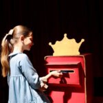 Niña interactuando con una caja de sugerencias en Expojove 2025