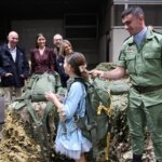 Niña recibiendo una mochila de un soldado en Expojove 2025