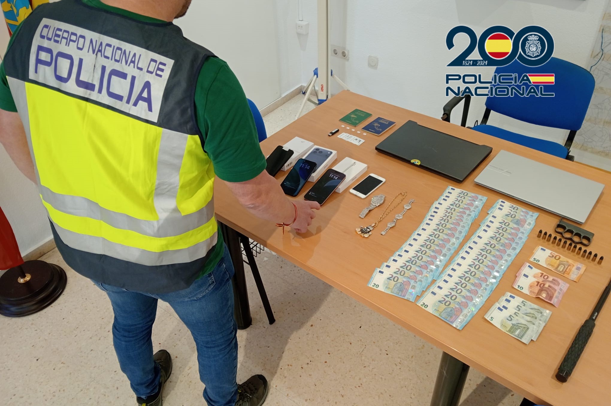 Agente de policía revisando objetos relacionados con una estafa en una mesa