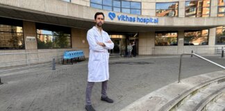 Médico en bata de laboratorio frente al hospital Vithas
