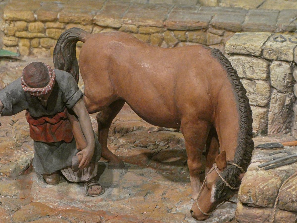 Escena de un hombre trabajando junto a un caballo en un entorno rústico.