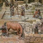 Representación de un pueblo antiguo con figuras trabajando en diversas tareas.