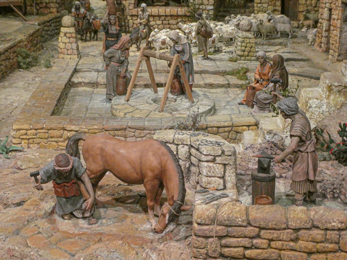 Representación de un pueblo antiguo con figuras trabajando en diversas tareas.