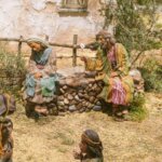 Figuras artesanales en una escena de belén con personajes sentados
