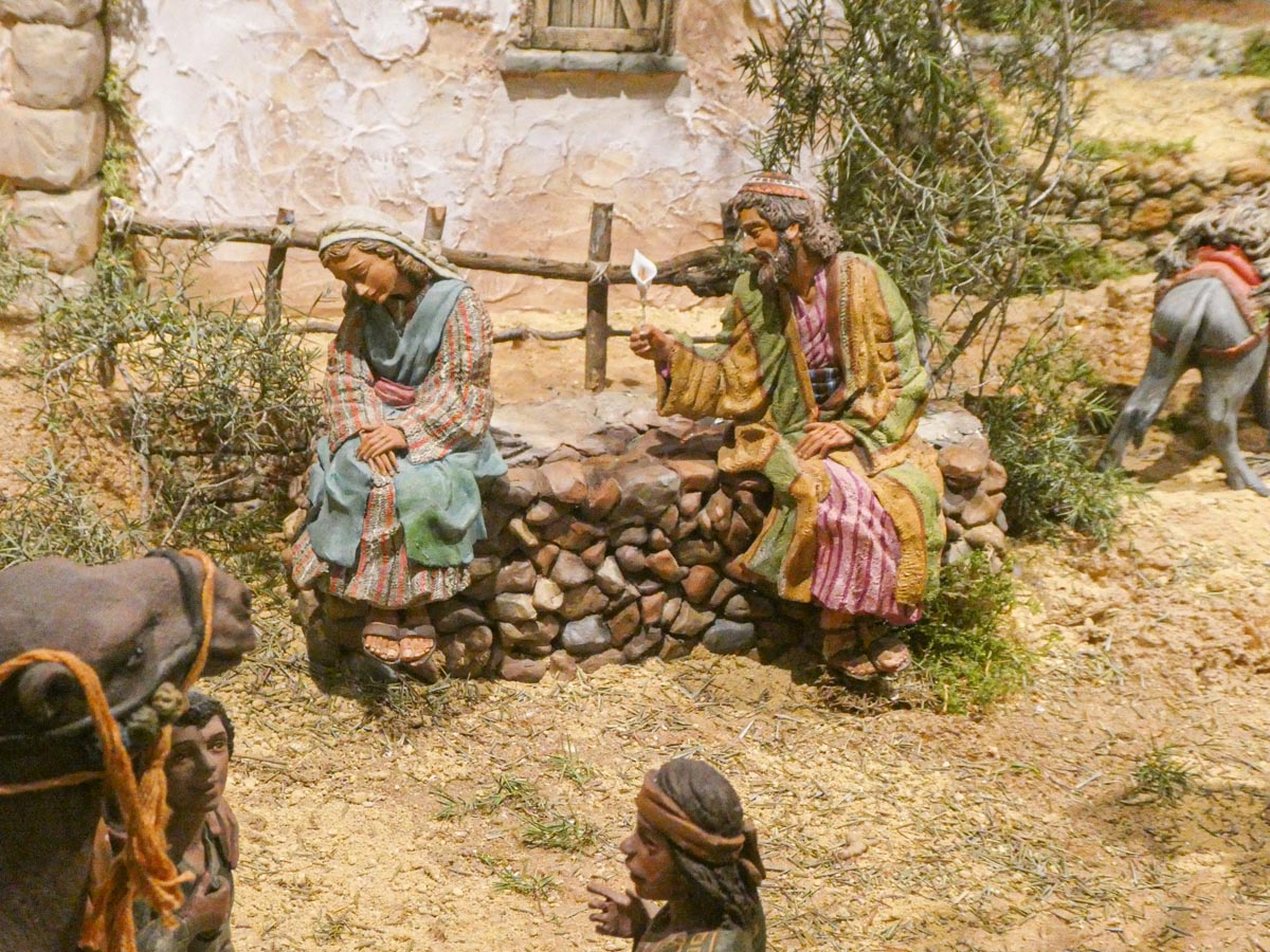 Figuras artesanales en una escena de belén con personajes sentados