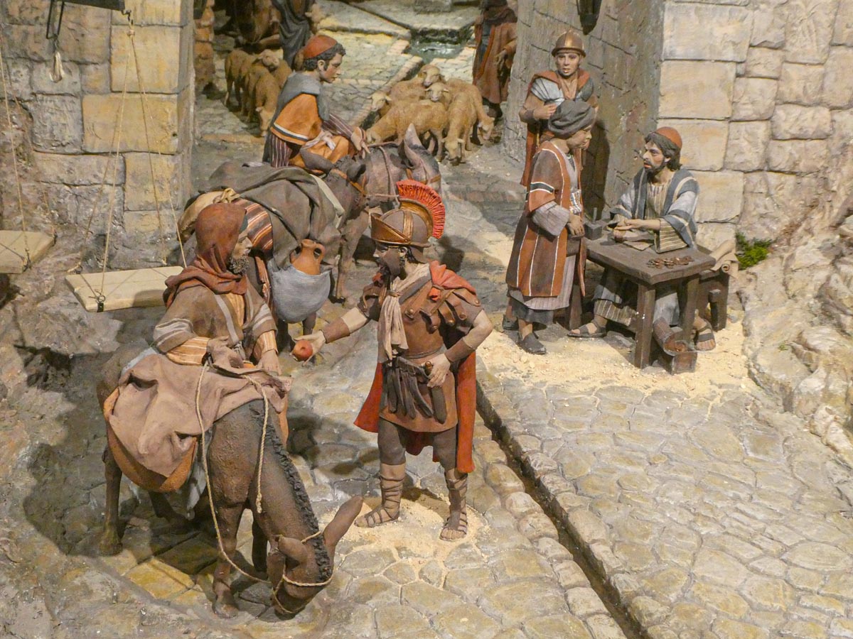 Representación de una escena histórica con figuras de artesanos y comerciantes.