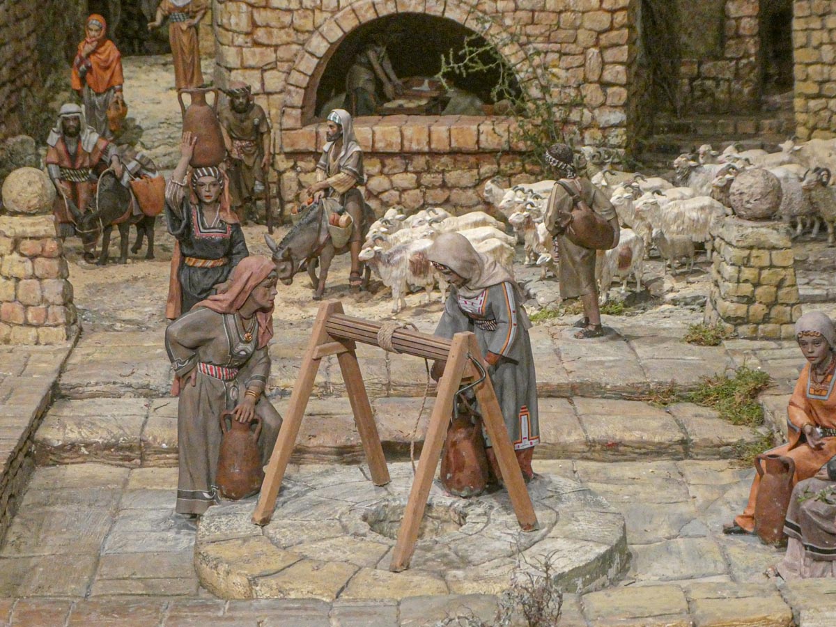 Representación de artesanos en un pueblo antiguo con ovejas.