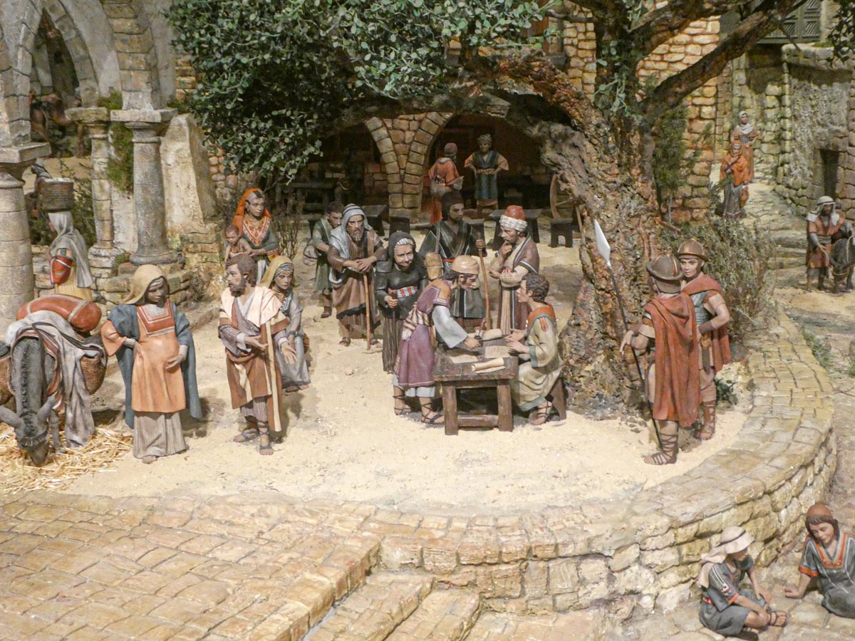 Representación de una escena histórica con artesanos y comerciantes en un pueblo antiguo.