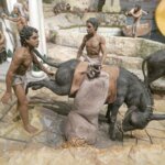 Escena de figuras humanas cargando un asno con sacos.