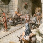 Escena histórica con figuras artesanales en un entorno medieval.