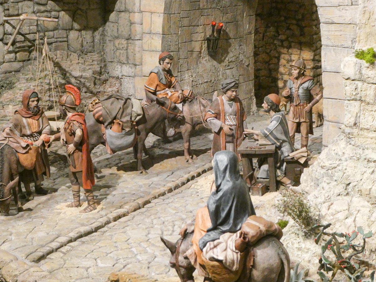 Escena histórica con figuras artesanales en un entorno medieval.