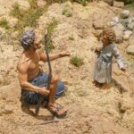 Figura de un hombre y un niño en un entorno natural