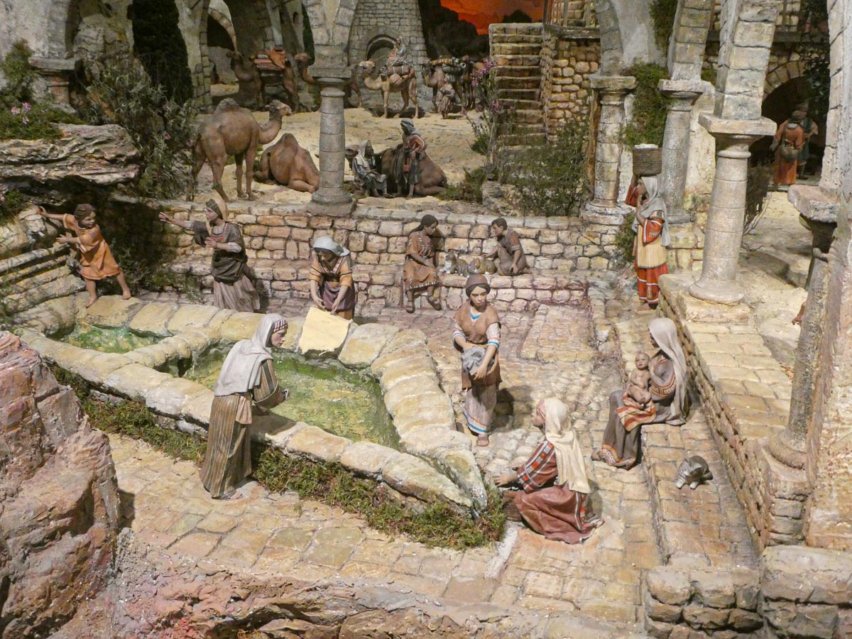 Representación de una escena de un pueblo antiguo con figuras en un entorno rural.