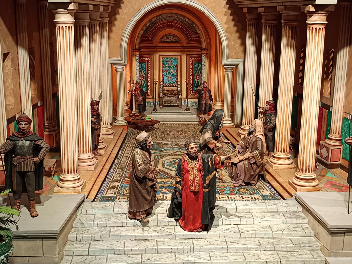 Recreación de una escena histórica con figuras en un entorno arquitectónico