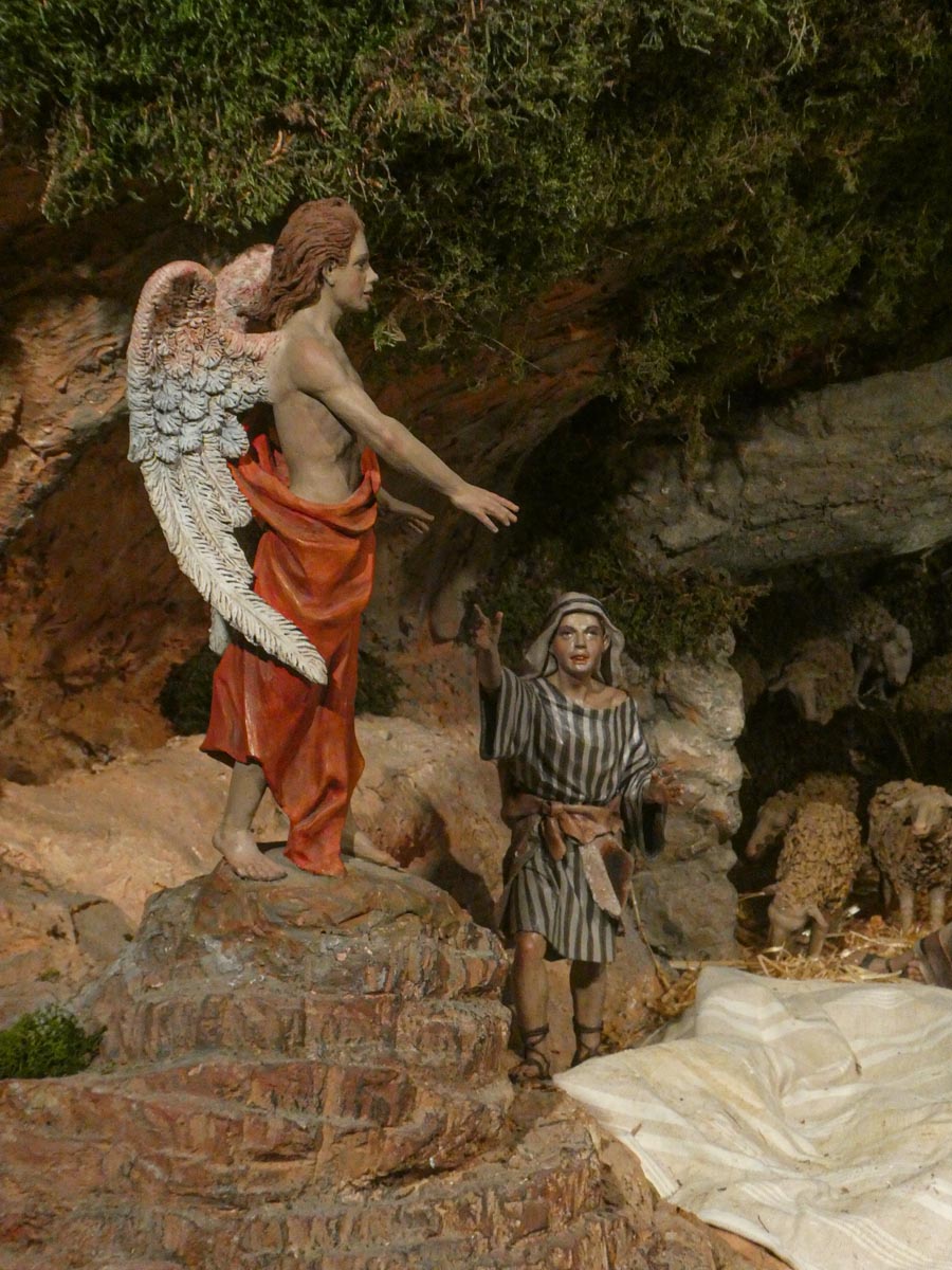 Escena de la natividad con un ángel y un pastor.