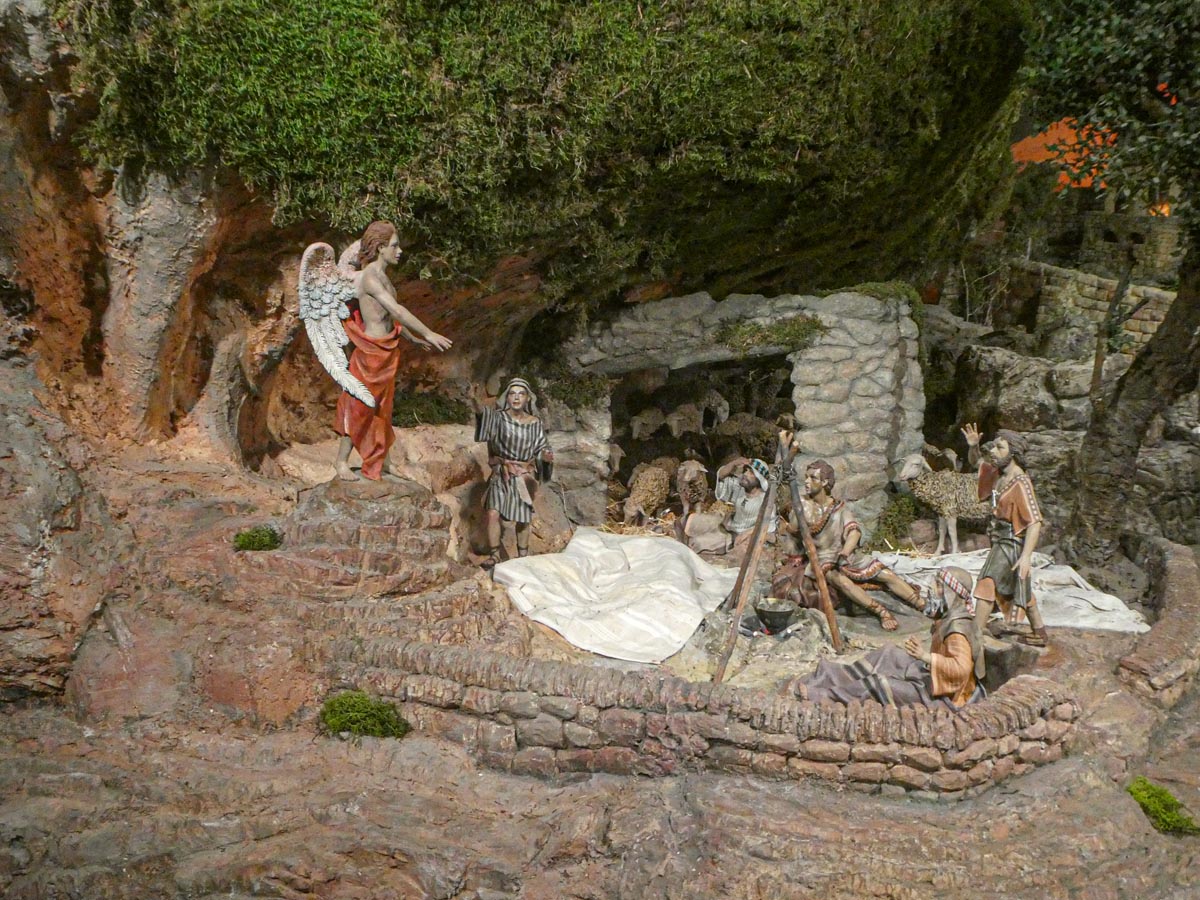 Escena de la natividad con un ángel y pastores en un belén